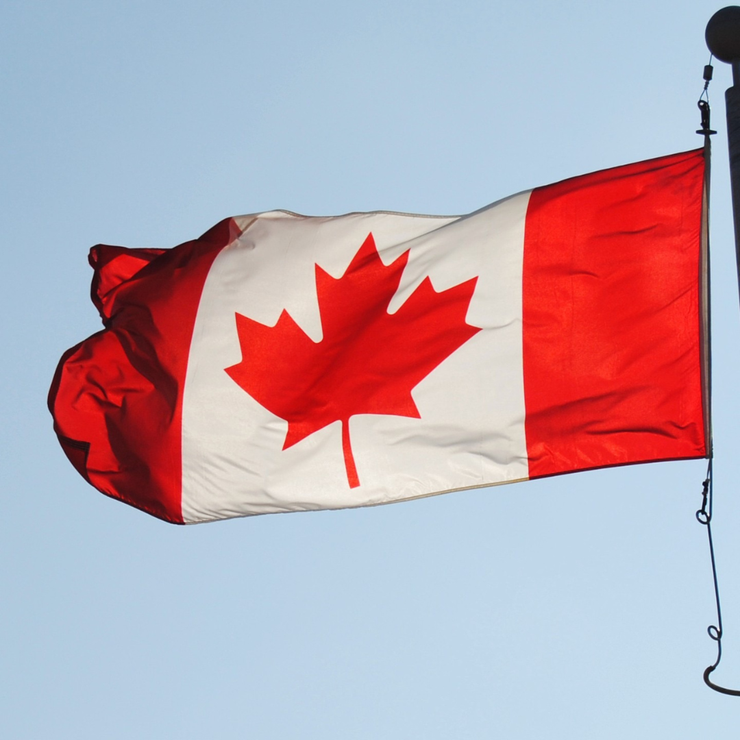 UBCS |A Canadian flag waves proudly in the wind outside a dental office in Canada, symbolizing national pride and community.